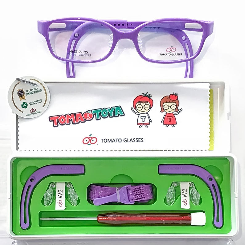 Purple tomato glasses with parts kit underneath. Parts kit has a white cloth with logo and 2 people wearing tomato hats on their head, purple ear tips, headband, nose pieces and screw driver sitting in kit surrounded by green background